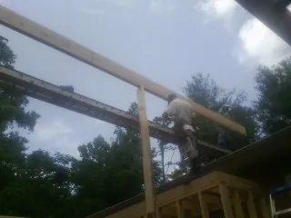 Carpenter setting a ridge beam over a new addition frame — Ice Dam Removal by Roofing Brothers in Seaside