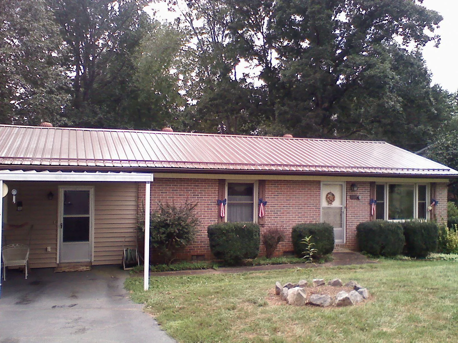 Bronze metal roof and carport on a brick ranch home — Roof Repair work by our crew in Seaside